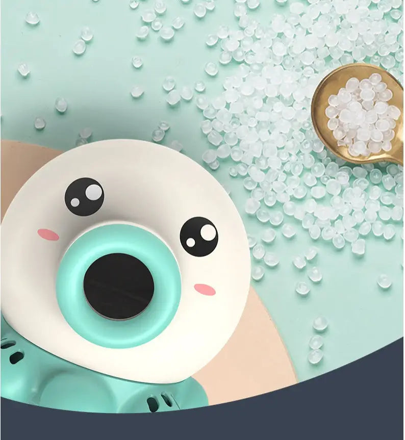 Jouet de bain interactif pour bébé avec un design mignon, entouré de perles transparentes sur fond pastel.